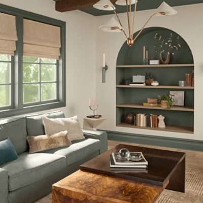 Living Room with light fixture, coffee table, couch, windows, bookshelf with decor.